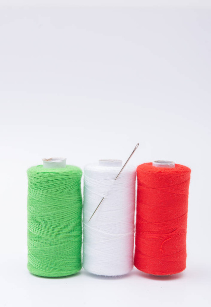 Διάφορα καρούλια από νήμα ραψίματος βαμβακιού διαφόρων χρωμάτων Ιταλική σημαία σε λευκό - Φωτογραφία, εικόνα
