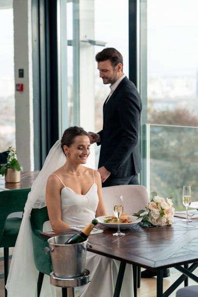 笑顔の恋人のグロムの肖像画は,お祝いの間にレストランで結婚式で新婚夫婦の世話をする - 写真・画像