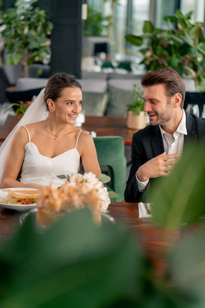 Portrait eines lächelnden Brautpaares, das sich verliebt, Hochzeit im Restaurant während der Feier der Liebesromantik - Foto, Bild