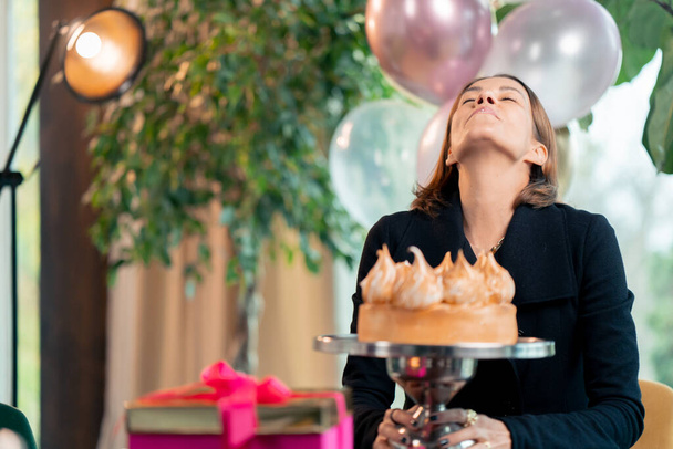 Porträt eines glücklichen Geburtstagskindes bei einem festlichen Kuchen während einer Party im Restaurant mit Geschenken - Foto, Bild