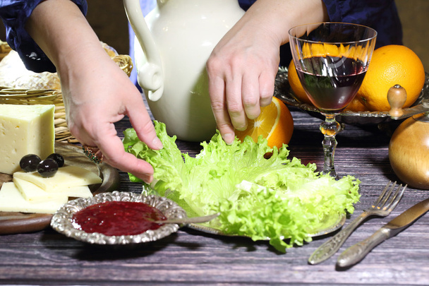 Las manos femeninas exhiben las hojas de la ensalada verde en el plato
 - Foto, imagen