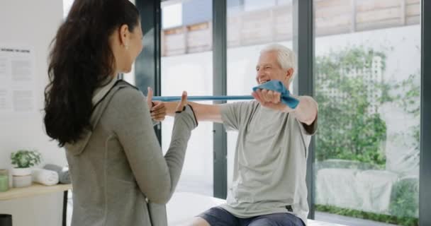 Physical therapy band, woman doctor and senior man exercise for arthritis and healthcare. Physiotherapist, elderly patient and wellness in a orthopedic recovery center with support for injury. - Felvétel, videó