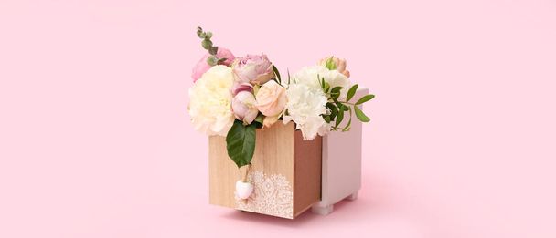 Piękna kompozycja kwiatowa w drewnianym pudełku na różowym tle - Zdjęcie, obraz