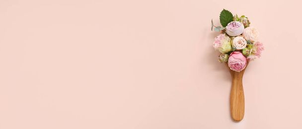 Композиція з дерев'яним пензлем для волосся і красивими трояндовими квітами на рожевому фоні з простором для тексту - Фото, зображення
