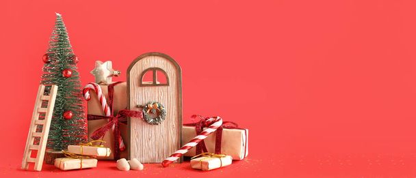 Miniaturas navideñas con regalos sobre fondo rojo con espacio para texto - Foto, imagen