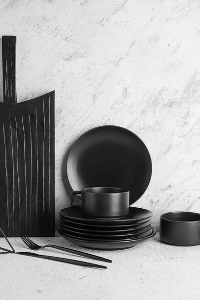Set de vajilla de cerámica negra sobre mesa blanca - Foto, imagen