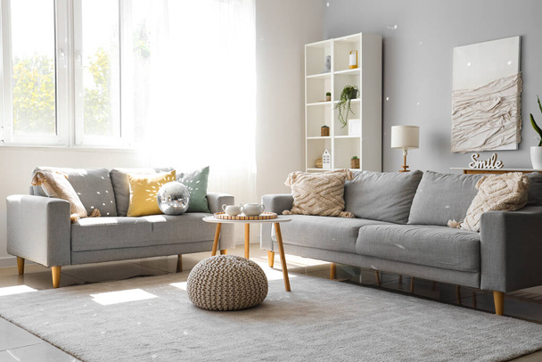 Interior da moderna sala de estar com sofás cinzentos, bola de discoteca e mesa de café - Foto, Imagem