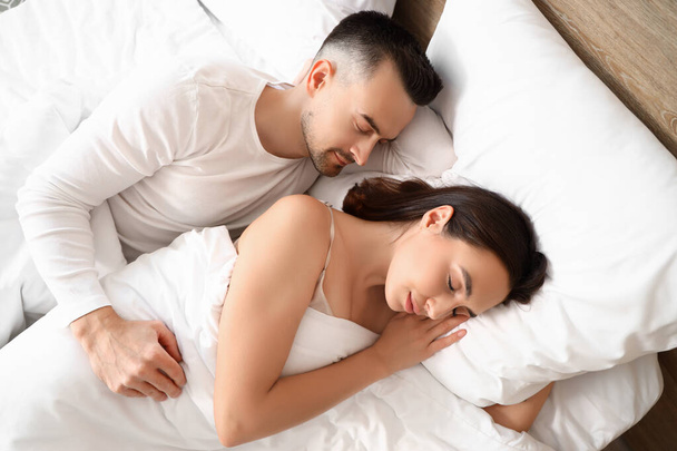 Νεαρό ζευγάρι κοιμάται στην κρεβατοκάμαρα - Φωτογραφία, εικόνα