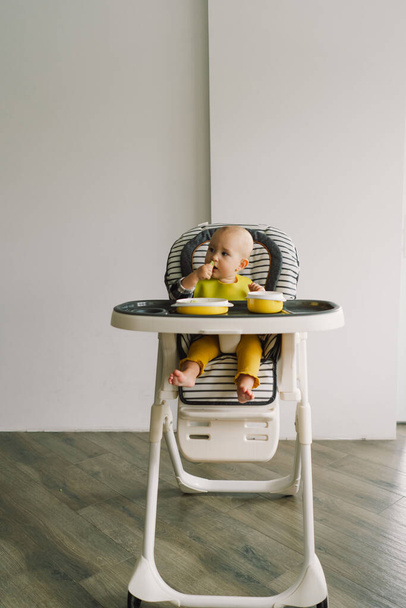 Klein kind met vaste voeding. Baby meisje eet vinger voedsel en meng groenten bord. Baby led spenen BLW zelf voeden. - Foto, afbeelding