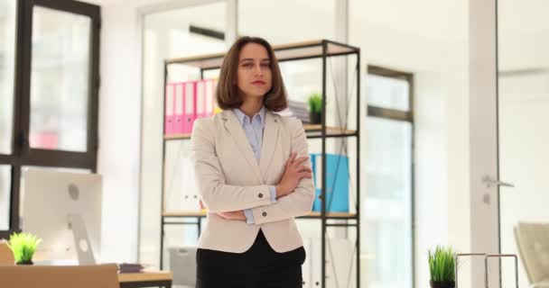 Uśmiechnięta piękna bizneswoman stojąca w nowoczesnym biurze. Portret młodego kierownika biura patrzącego w kamerę z dobrym humorem - Materiał filmowy, wideo