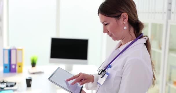 Az orvos digitális tabletet tart kardiogrammal a klinikán. Szívbetegség vizsgálata és kezelése - Felvétel, videó