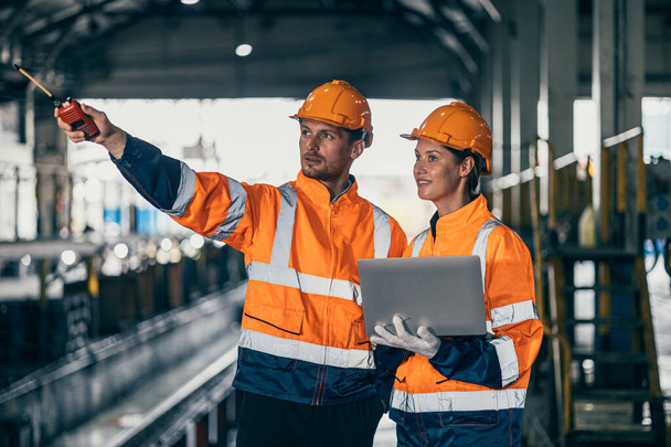 Mérnök biztonsági tiszt csapat férfi és a nők együtt dolgoznak laptop ellenőrzés ellenőrzés nehéz ipari épület gyár. - Fotó, kép