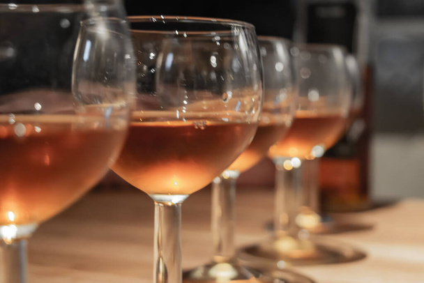 Fila di bicchieri da vino ros, diversi vini come il vino arancione, il vino vanigliato e il vino al cacao - Foto, immagini