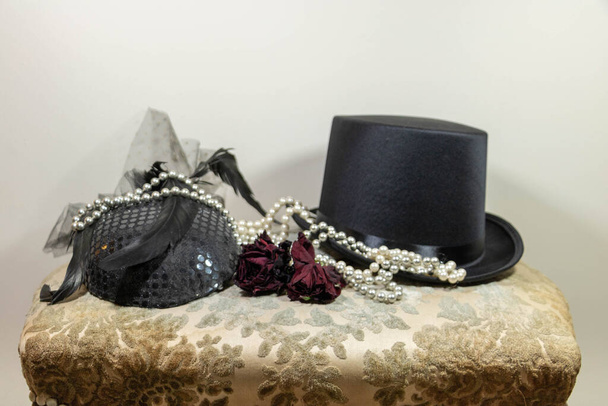 Elegantní módní doplňky klobouky, perlový náhrdelník a růže pro boutonniere, cylindr a závoj fascinátor klobouk - Fotografie, Obrázek