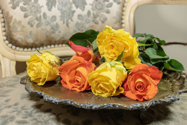 Ramo de rosas colocado en una bandeja de cobre en el tocador de Madame - Foto, Imagen