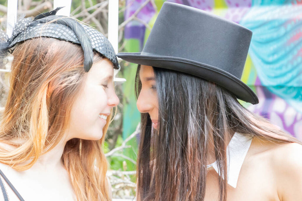 Весела лесбійська пара з чорним верхнім капелюхом і завуальованим захоплюючим, в стімпанк вбрання на святкуванні в місці урбексу - Фото, зображення