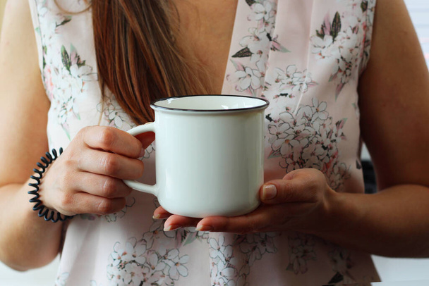 Woman holding blank white coffee mug mockup. White mug mock up for your company logo and design. - Photo, Image