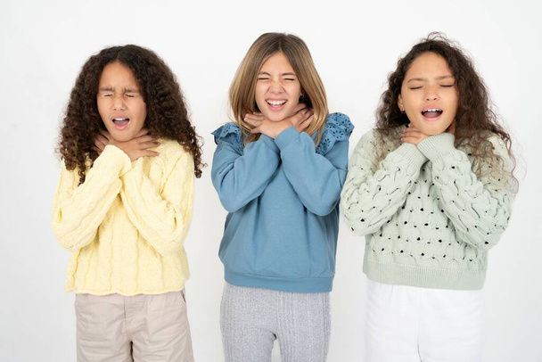 Tři mladé krásné multiiraciální holčičky křičící se udusí, protože je to bolestivé škrcení. Zdravotní problém. Zadušení a sebevražedný koncept. - Fotografie, Obrázek