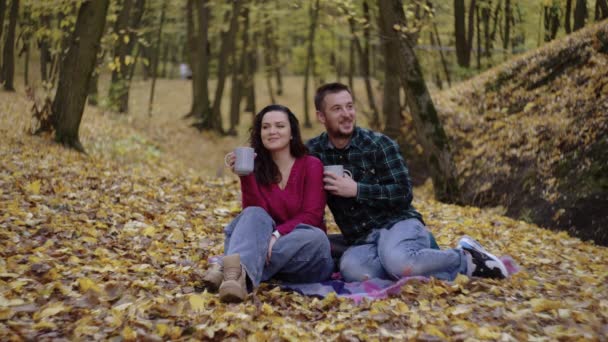 Romantisch Europees paar genieten van thee, omarmen van de kalme schoonheid van de herfst in het park. Hoge kwaliteit 4k beeldmateriaal - Video