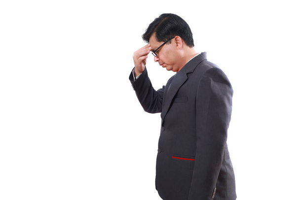 Πλευρική άποψη του στρεσαρισμένου Ασιάτη επιχειρηματία να στέκεται κρατώντας το κεφάλι του, να υποφέρει από πονοκέφαλο. Απομονωμένα σε λευκό - Φωτογραφία, εικόνα