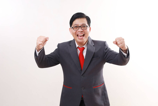 成功を祝いながら立っているアジアのビジネスマン. 白い背景に隔離される - 写真・画像