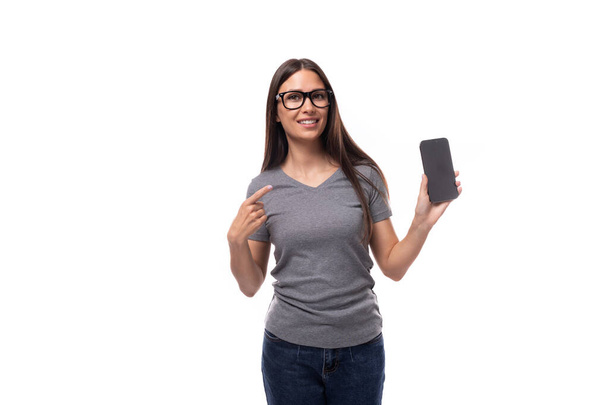 retrato de uma jovem branca pensiva magro em óculos mostrando tela do smartphone. - Foto, Imagem