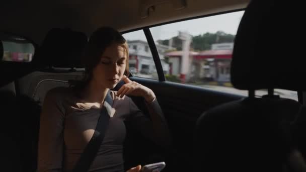 Meisje rijdt in een taxi en met behulp van een mobiele telefoon. - Video