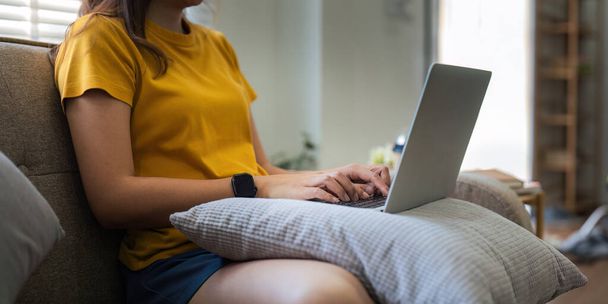 Mladá žena asijské pomocí notebooku PC na gauči relaxovat surfování na internetu doma. koncept relaxace životního stylu. - Fotografie, Obrázek