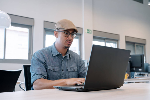 Hombre trabajando con un portátil en su escritorio en la oficina. Concepto empresarial. - Foto, imagen
