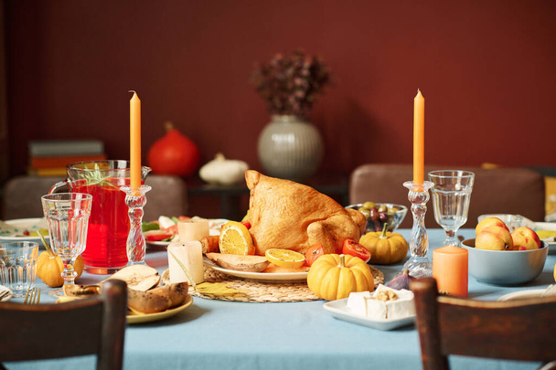 Medium volledige shot van geroosterde kalkoen weergegeven op thanksgiving feestelijke tafel onder andere traktaties - Foto, afbeelding