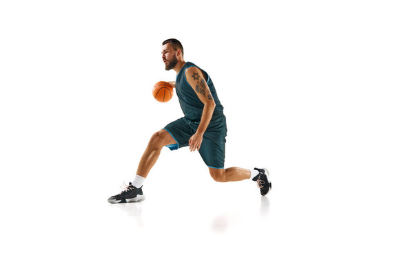 Basketbalspeler, atletische man workout in beweging, benadrukken toewijding aan het perfectioneren van ambachtelijke tegen witte achtergrond. Concept van sport, hobby, actieve levensstijl, kracht en kracht. Kopieer ruimte, advertentie - Foto, afbeelding