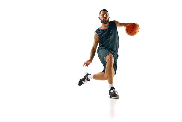 Intenzivní koncentrace basketbalisty během tréninku, zdůrazňující odhodlání k excelenci na bílém pozadí. Koncept sportu, koníčku, aktivního životního stylu, síly a síly. reklama - Fotografie, Obrázek