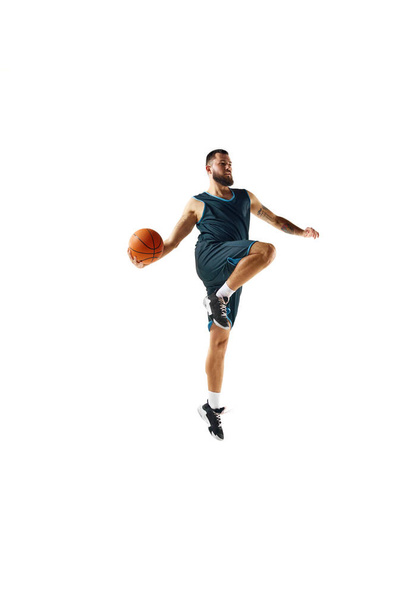Basketballspieler in Uniform demonstriert Stärke und Konzentration beim Training vor makellosem weißen Hintergrund. Konzept aus Sport, Hobby, aktivem Lebensstil, Kraft und Stärke. Kopierraum, Anzeige - Foto, Bild