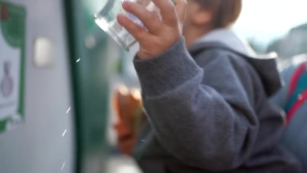 Effort du petit garçon dans le recyclage du verre, Placer la bouteille à la main dans la poubelle, concept environnemental vert - Séquence, vidéo