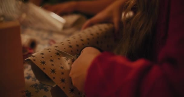 Розрив жіночого різання подарункового паперу на Різдво вдома - Кадри, відео