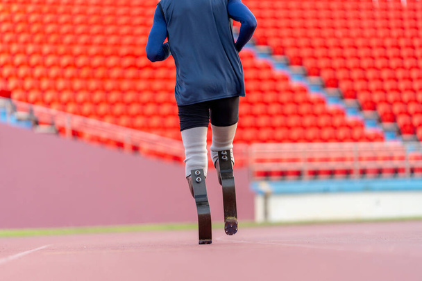 Back of Sport man athlete prosthesis legs run or jogging in the track of the stadium to practice and prepare himself for the competition. - Photo, Image