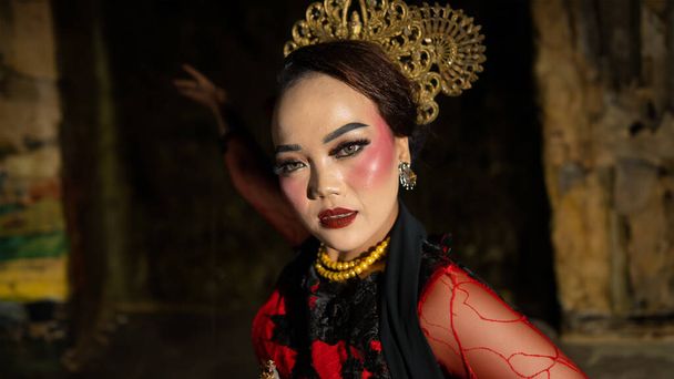 indonezyjski tancerz z wyrazem twarzy, który promieniuje pięknem i szczęściem tańczy i urzeka widzów w nocy - Zdjęcie, obraz