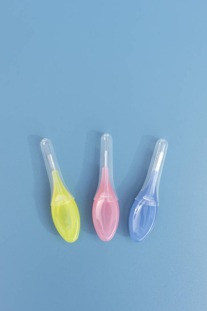 Πρότυπο Πολύχρωμο οδοντόβουρτσες ανάμεσα στα δόντια Gum Braces σε μπλε φόντο, οδοντική βούρτσα οδοντογλυφίδα με μαλακές τρίχες, στοματικό εργαλείο καθαρισμού δοντιών. Κατακόρυφο αεροπλάνο, αντίγραφο χώρου για κείμενο. Υψηλή - Φωτογραφία, εικόνα