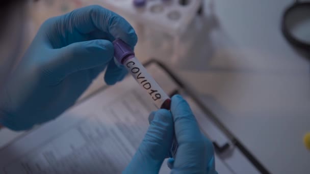 Ο γιατρός κρατάει δοκιμαστικό σωλήνα με αίμα για ανάλυση 2019-nCoV. Νόσος του Coronavirus COVID-19 πανδημία. Ιατρική περίθαλψη έννοια, δοκιμή του ιού. Έλεγχος του πληθυσμού για ανοσία στο covid 19. - Πλάνα, βίντεο