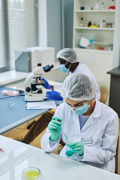 Vertikale Aufnahme eines medizinischen Labors mit zwei Wissenschaftlern, die an der Forschung arbeiten - Foto, Bild