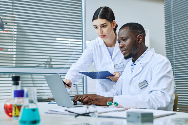 Προσωπογραφία δύο επιστημόνων που χρησιμοποιούν φορητό υπολογιστή ενώ κάνουν έρευνα σε ιατρικό εργαστήριο, αντιγραφή χώρου - Φωτογραφία, εικόνα