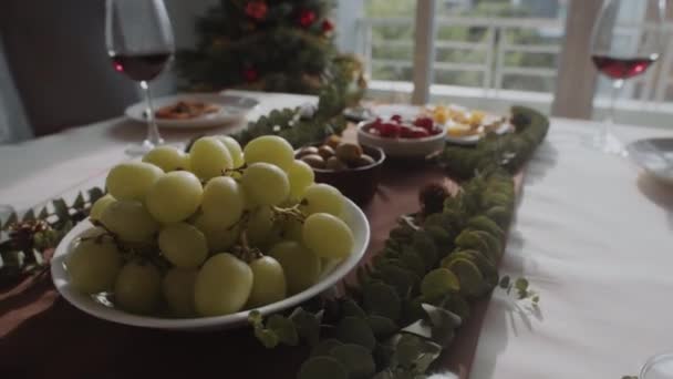 Handheld shot van olijven, kaas, tomaten en andere snacks aan feestelijke tafel geserveerd voor kerstviering - Video