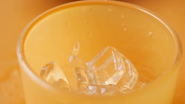 versando bevande analcoliche in un bicchiere con cubetto di ghiaccio . - Filmati, video