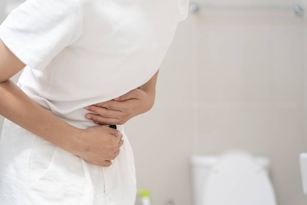 Constipation and diarrhea in bathroom. Hurt woman touch belly  stomach ache painful. colon inflammation problem, toxic food, abdominal pain, abdomen, constipated in toilet, stomachache, Hygiene - Photo, Image