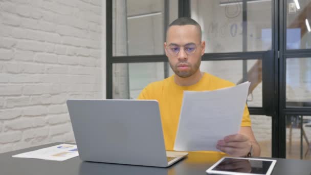 Homme hispanique travaillant sur des documents et un ordinateur portable - Séquence, vidéo
