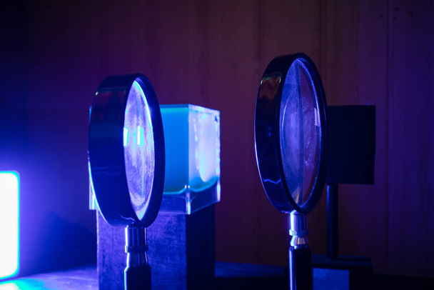Оптические линзы на подставках в синем свете в лаборатории - Фото, изображение