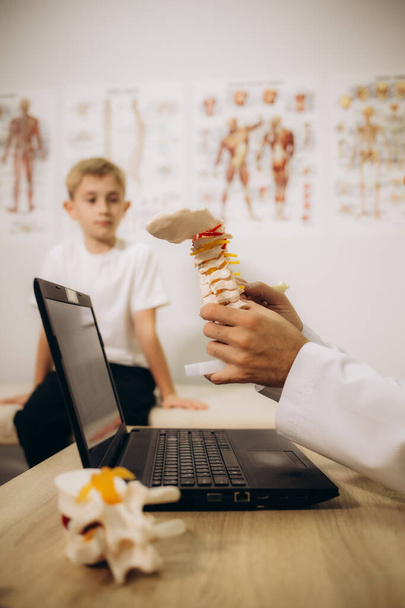 Orthopäde untersucht den Rücken des Kindes in der Klinik, Nahaufnahme. Skoliose-Behandlung.  - Foto, Bild