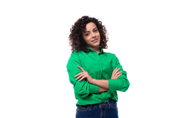 portrait of a 30 year old confident successful caucasian brunette woman with a curled hair dressed in a green shirt on a background with copy space. - Photo, Image