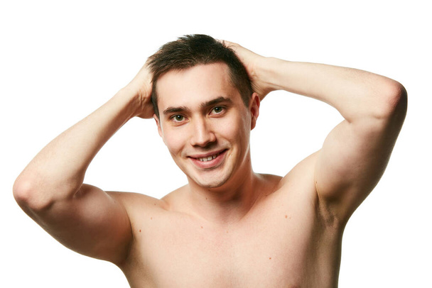 Muotokuva paidaton nuori brunette mies näyttää terveet hiukset ilman turkista vastaan valkoinen tausta. Käsitys kauneudenhoidosta ja hygieniasta, kehonhoidosta, ikääntymisen vastaisista menettelyistä. Kopioi tila. - Valokuva, kuva