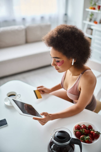 glückliche Afroamerikanerin shoppt online mit Tablet mit Kreditkarte in der Hand und Kaffee beiseite - Foto, Bild